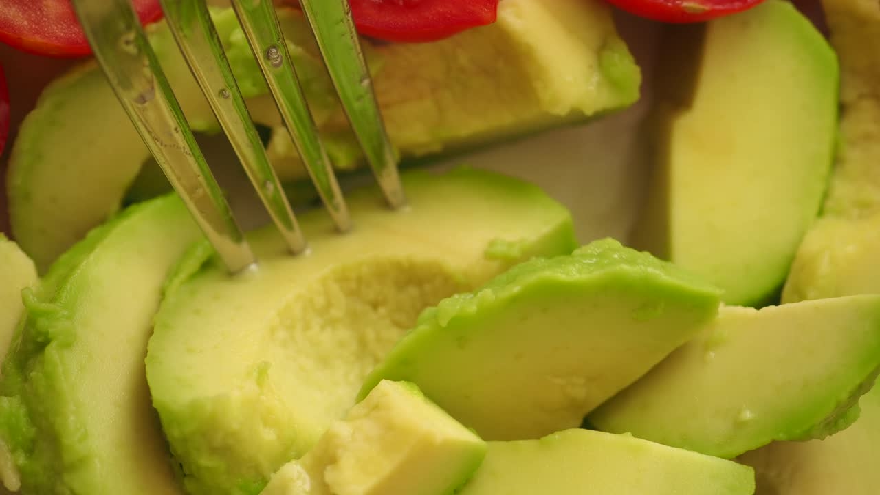 Primo piano di avocado fresco a fette con una forchetta