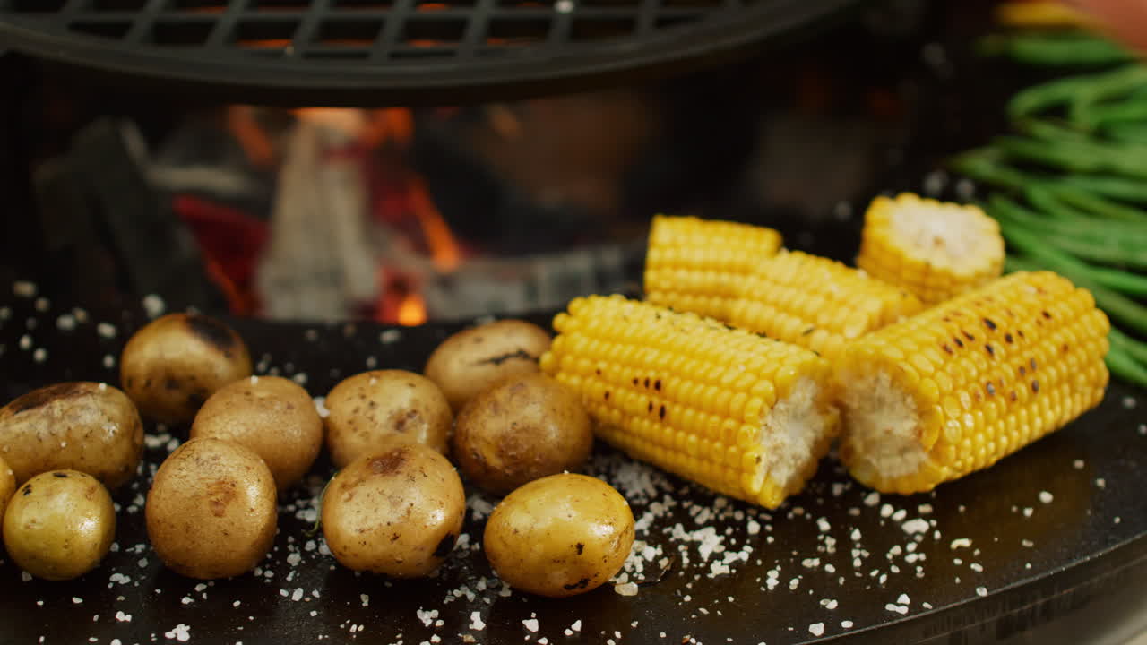 comida vegetariana preparada en la parrilla de barbacoa afuera. patata y maíz cocinados en la parrilla