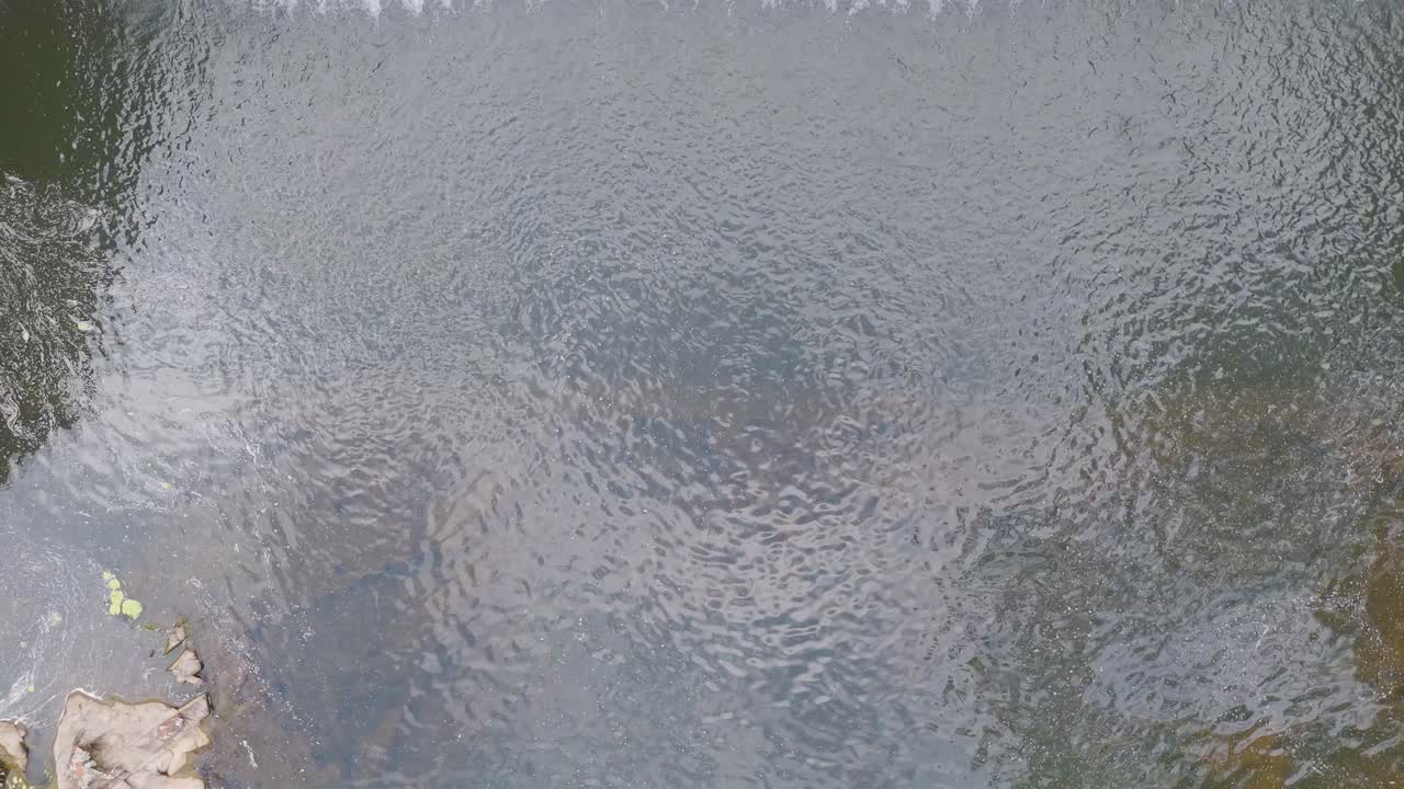 A serene view of water ripples with subtle reflections and natural lighting, creating a tranquil and peaceful atmosphere