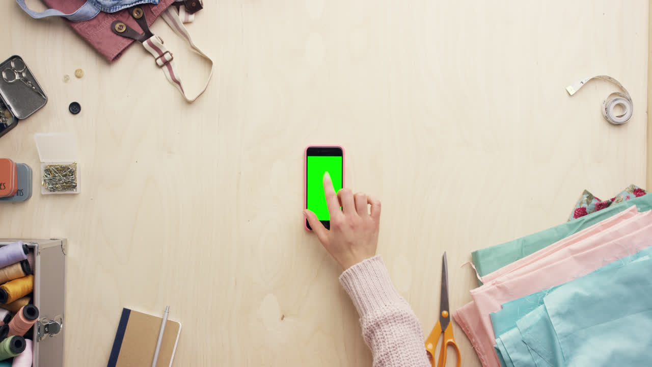 vista superior de las manos del diseñador de moda usando una aplicación de diseño de teléfono móvil trabajando en el escritorio desde arriba - dragón épico rojo