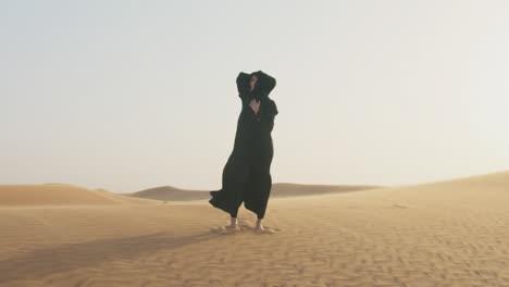 bella mujer descalza con hiyab posando en un desierto ventoso 1