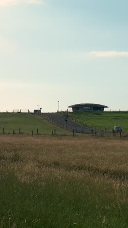 a rural landscape featuring a unique earth-sheltered house on a grassy hill
