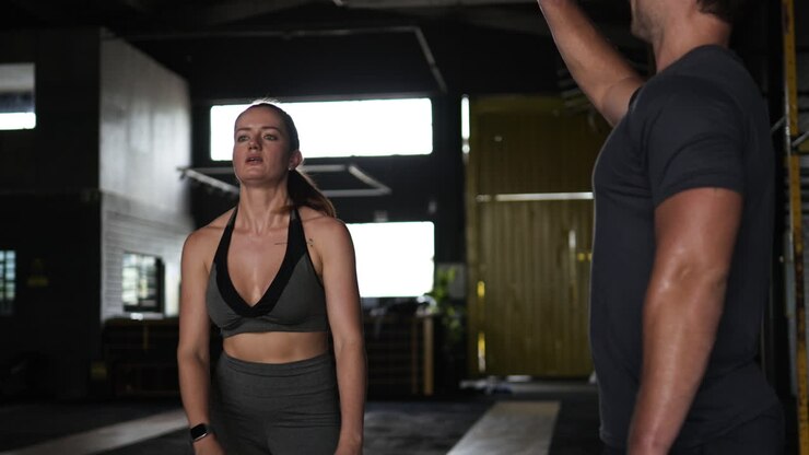 mujer trabajando con entrenador personal en el gimnasio