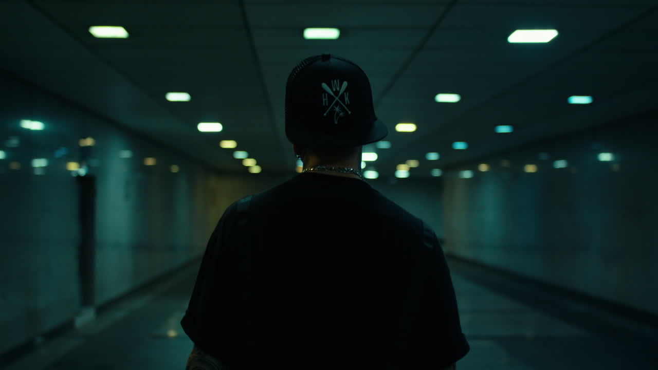 Man walking in a dark subway tunnel at night