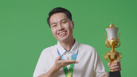 man holding a trophy and medal