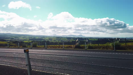 traveling on road in new zealand with view over amazing green country, slowmo