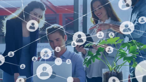animación de iconos conectados sobre diversos compañeros de trabajo discutiendo informes en la computadora portátil en la oficina