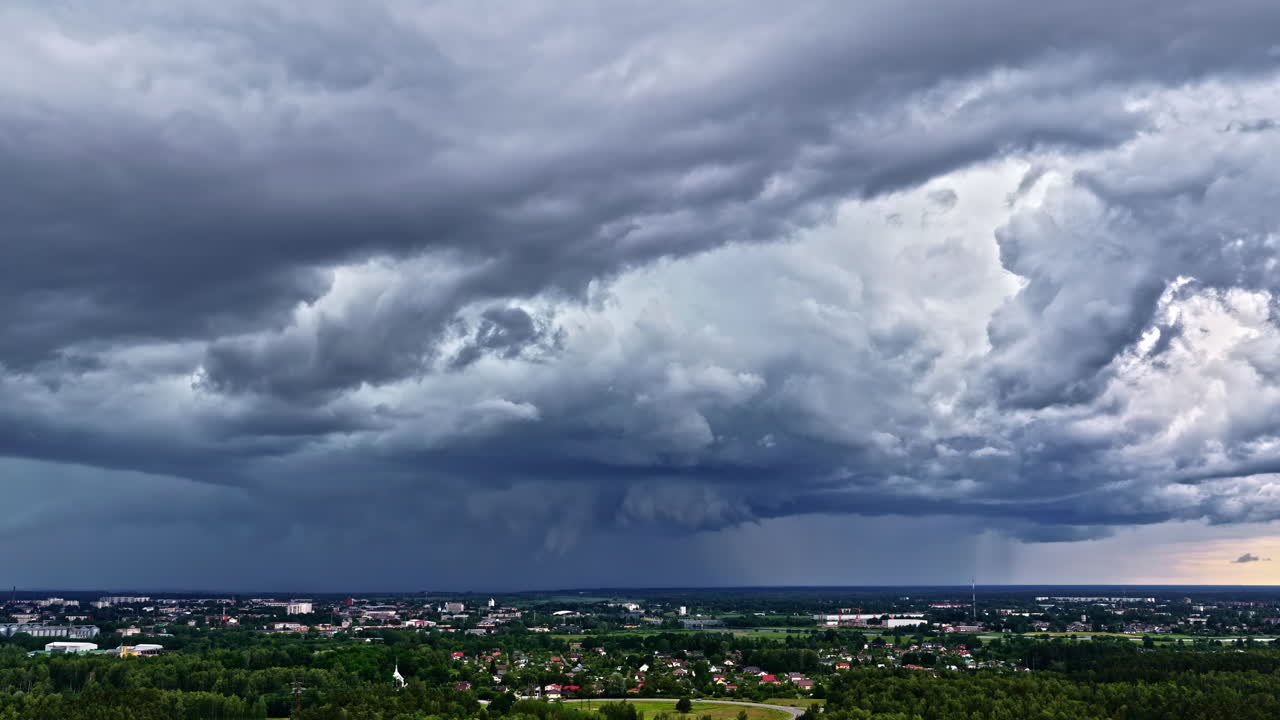 Dark storm clouds swirl over Jelgava, Latvia, as seen from above, highlighting dramatic weather and cityscape - Timelapse