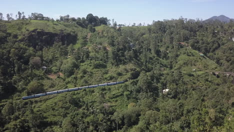 aerial: passenger train approaches famous nine arch bridge, sri lanka