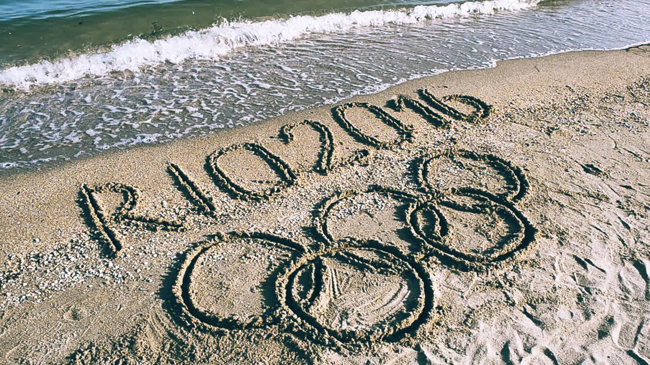 Rio 2016, un'iscrizione sulla sabbia della spiaggia. Simbolo dei Giochi Olimpici sulla sabbia della spiaggia.