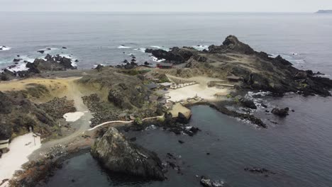 low flat light flyover rugged ocean headland at caleta chanaral, chile