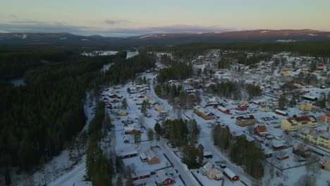 Camión-De-Bomberos-En-Una-Conducción-De-Emergencia-A-Través-Del-Barrio-De-La-Villa-Cubierta-De-Nieve-Junto-Al-Bosque-De-Abetos,-Escandinavia,-Antena