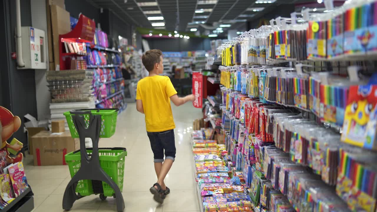 Boy choosing school supplies. Portrait of school boy shopping at supermarket
