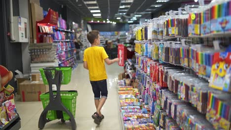 boy choosing school supplies. portrait of school boy shopping at supermarket