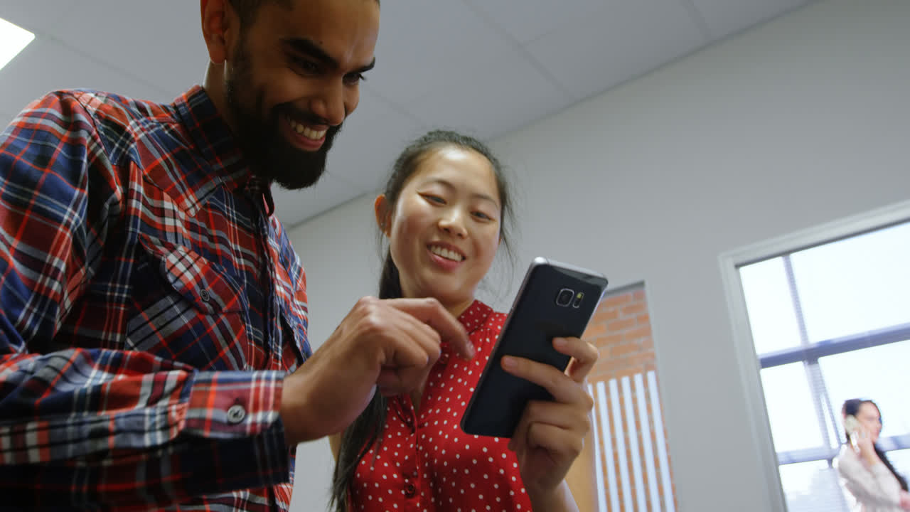 Business executives discussing over a mobile phone 4k
