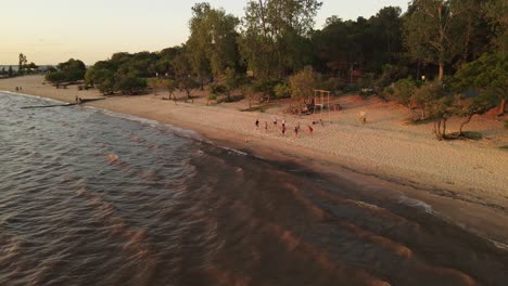 people playing beach volley at dusk along fray bentos shore in uruguay