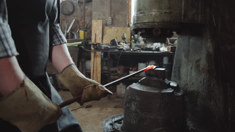 blacksmith forging metal with power hammer