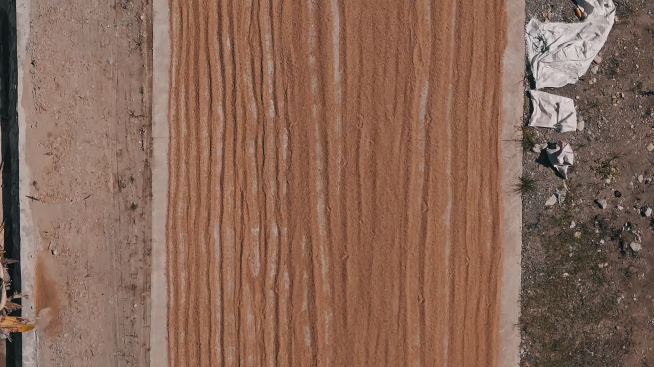 una larga fila de arroz extendida en un camino para secarse al sol - filipinas