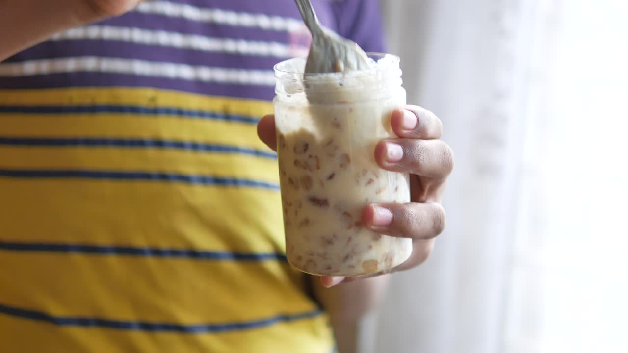 아이 가 항아리 에서 집 에서 만든 디저트 를 먹고 있다