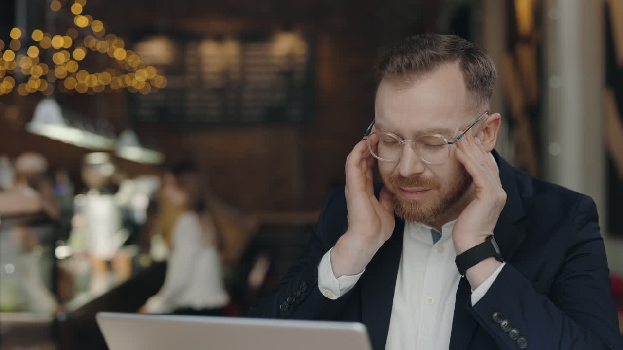 Man with Headache in Cafe