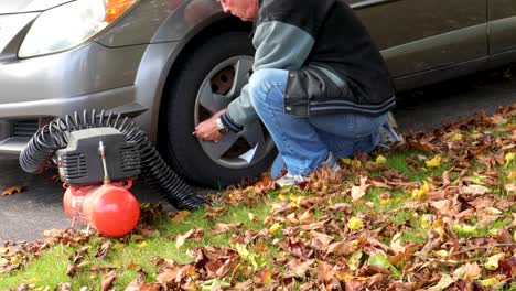 a man checks the car's tire pressure, adds too much air and releases the excess