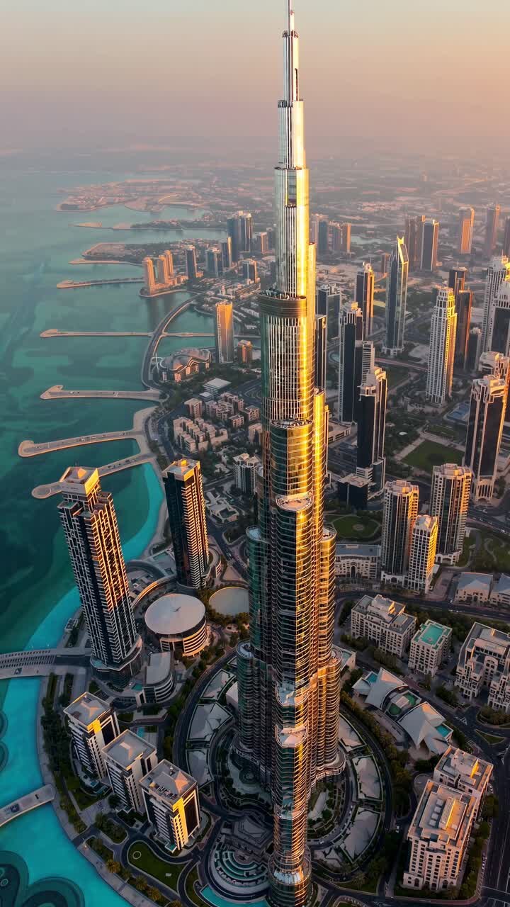 Aerial view video of a modern skyscraper at sunset, showcasing urban architecture and surrounding