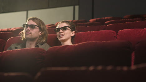 Pareja-Con-Gafas-3d-Sentada-En-El-Cine-Mientras-Hablan-Y-Ven-Una-Película-1