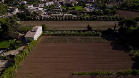 Aerial-revealing-shot-of-downtown-Pezenas-with-agricultural-fields-surrounding