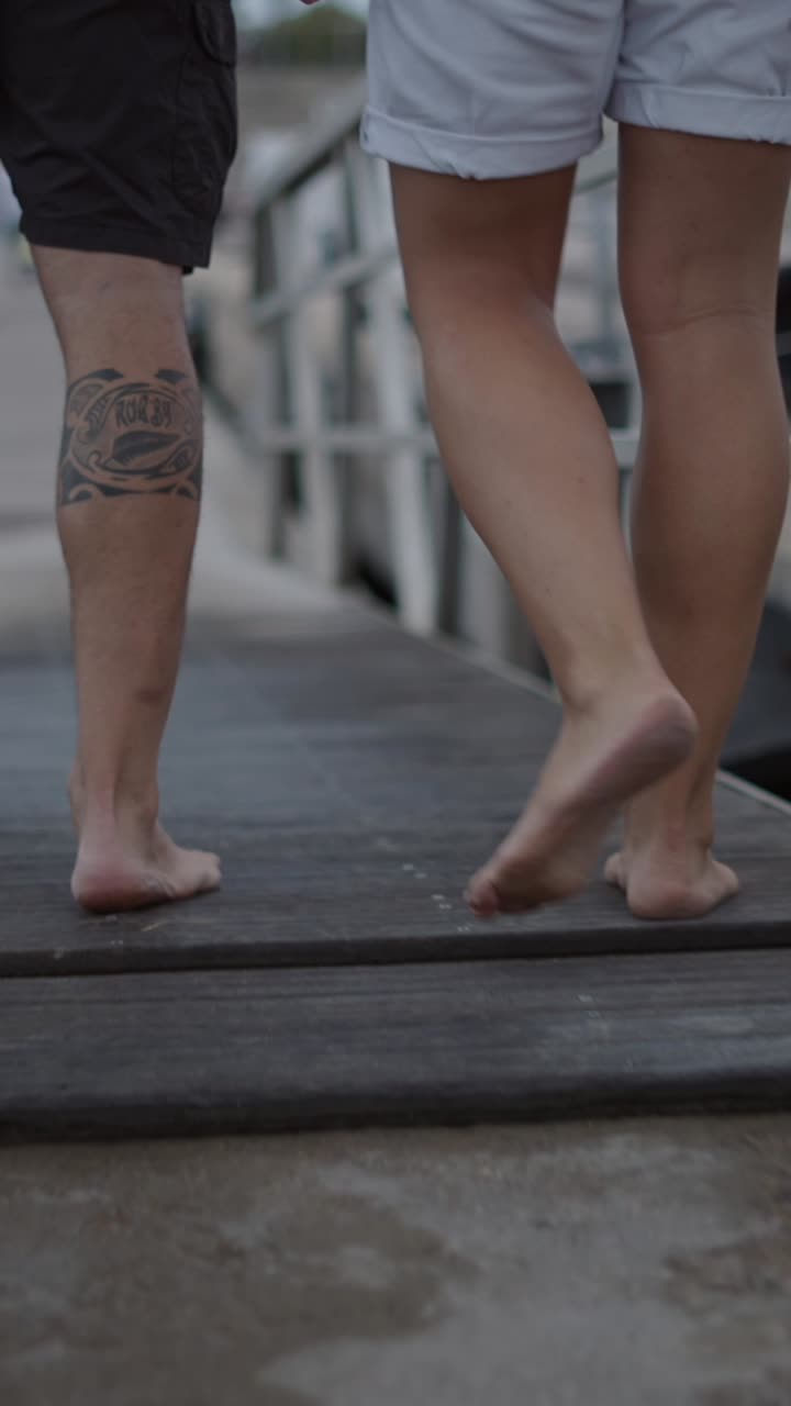 People walking barefoot on a pier