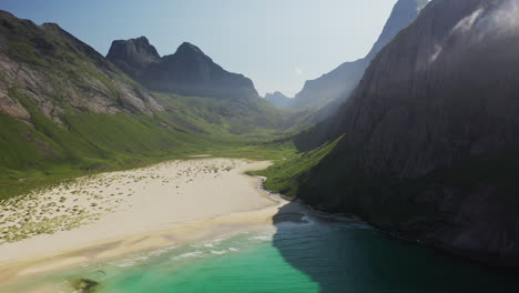 wide rotating drone shot of horseid beach with turquoise blue water, clouds moving over cliffs