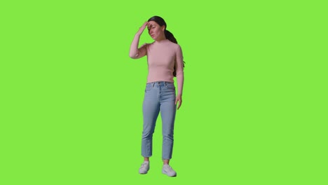 full length studio portrait of frustrated angry woman shouting off camera standing against green screen 1