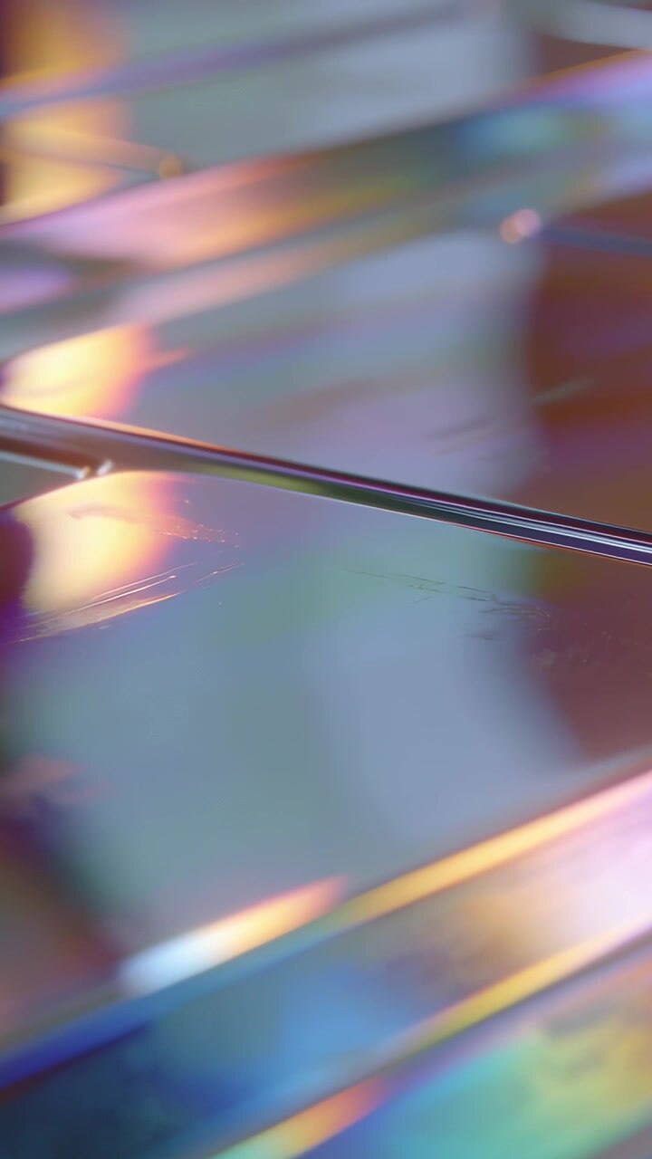 Video verticale: Angolazione della telecamera che cambia, mostrando sottili aste metalliche su un foglio iridescente, rivelando un giunto.