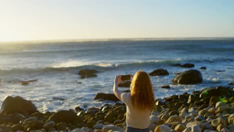 woman taking photo by the shore 4k