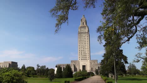 Louisiana-state-capitol-building-in-Baton-Rouge,-Louisiana-with-gimbal-video-walking-forward-with-trees