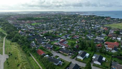 neighborhood of halsskov and korsor next to great belt bridge in denmark - aerial during morning sunrise