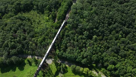 an aerial view of the moodna viaduct, a steel railroad trestle in cornwall, ny with a train on it