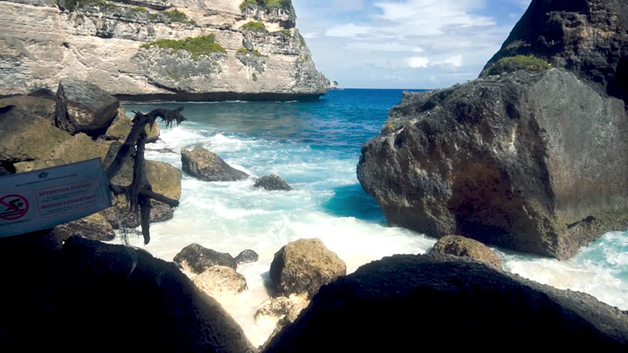 발리에서 화창한 날 동안 바위 해안을 부수는 파도의 핸드헬드 샷