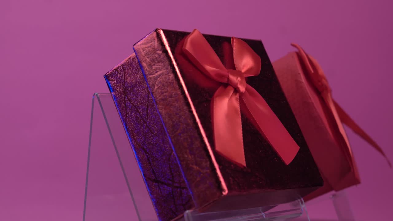 Due scatole regalo rosse per San Valentino su sfondo rosa. Primo piano