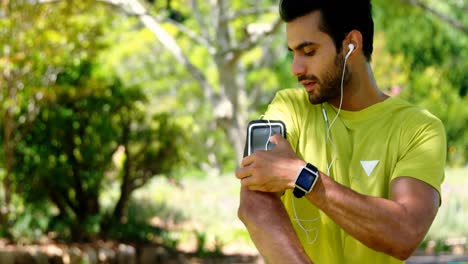 Jogger-man-touching-the-mp3-player-in-armband-4k