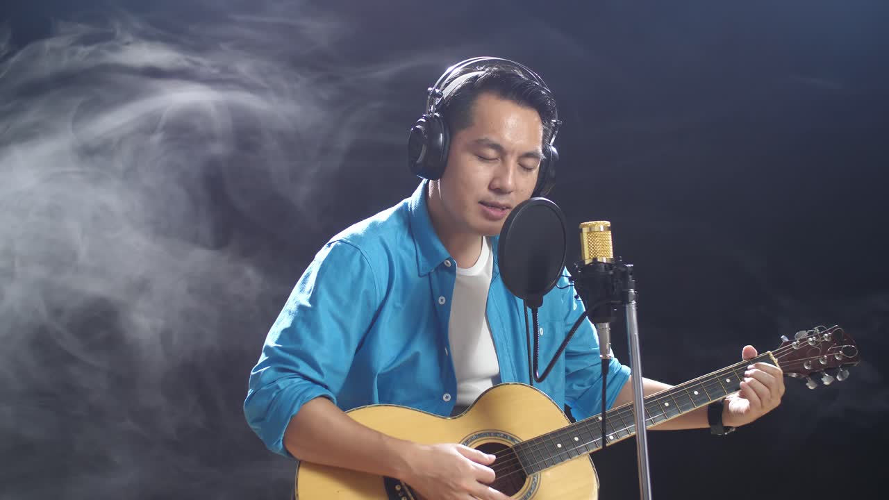 노래 하고 어쿠스틱 기타를 연주 하는 남자