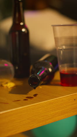 Vertical-Video-Close-Up-Of-Empty-Wine-And-Bottle-Dripping-On-Table-After-House-Party