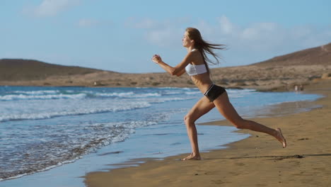 chica deportiva en una playa haciendo ejercicios de estocadas. concepto de un estilo de vida saludable