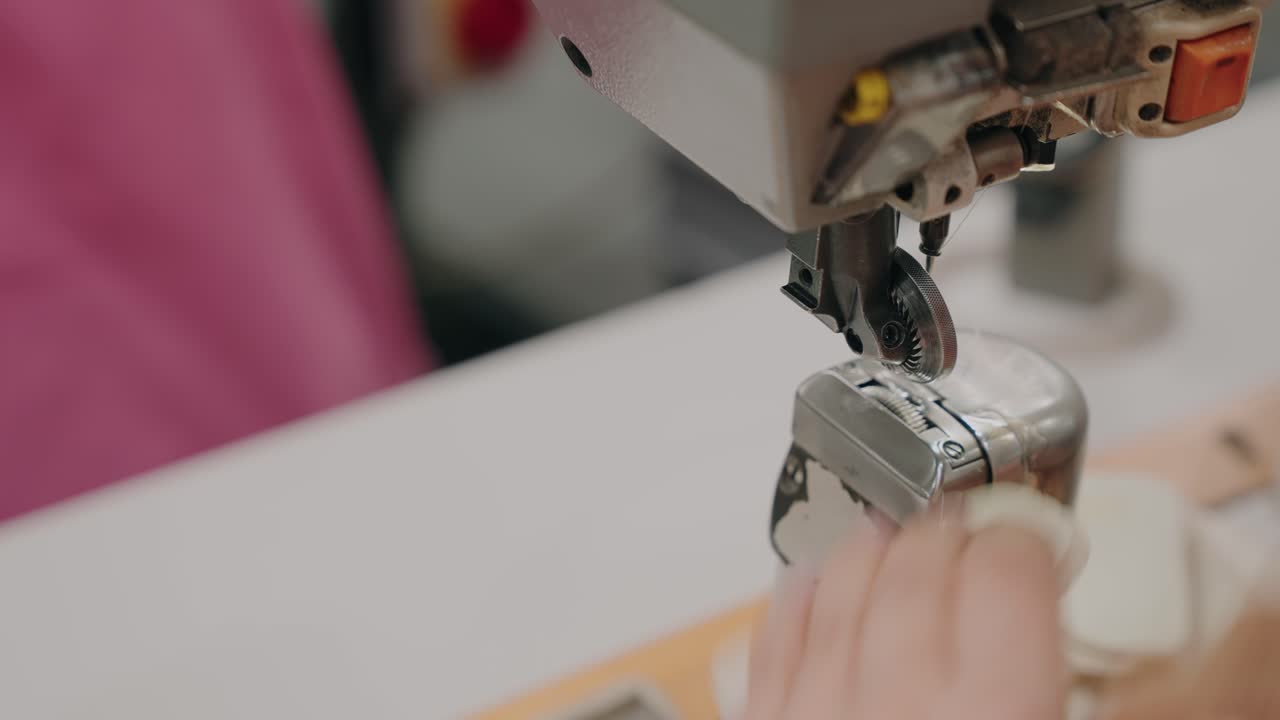 detailed view of tailor stitching fabric using professional sewing machine