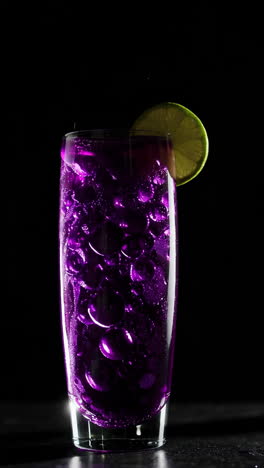 vibrant purple cocktail with unique bubbles and lime garnish