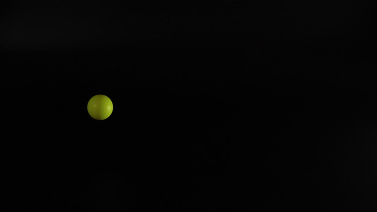 노란색 공이 어두운 배경에 반사되고 있습니다.