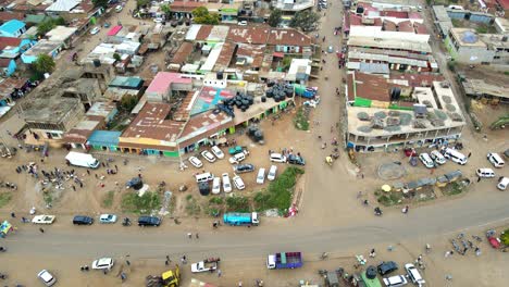 Aerial-view-of-cars-and-people-at-a-Open-Air-Market,-in-Africa---reverse,-drone-shot
