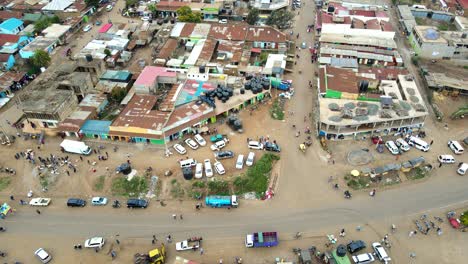 aerial view of cars and people at a open air market, in africa - reverse, drone shot