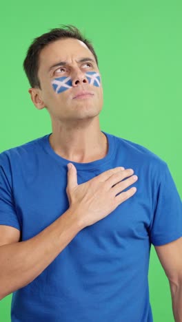 man listening to the scotland national anthem with solemnity