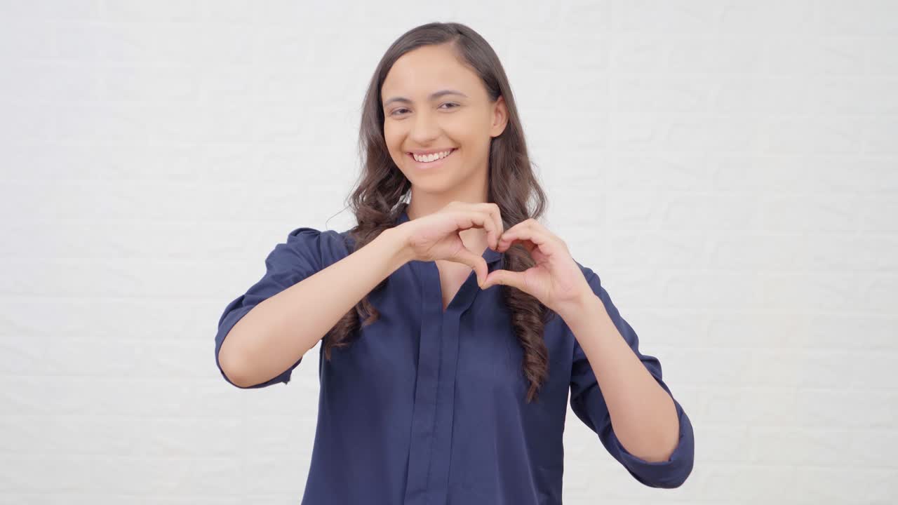 인디언 소녀가 심장 제스처를 보여주고 있습니다.