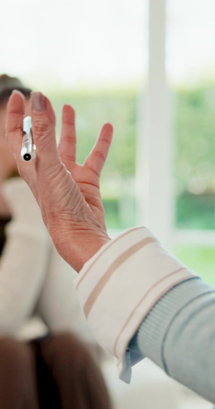 Close-up of Person Gesturing with Pen During Conversation